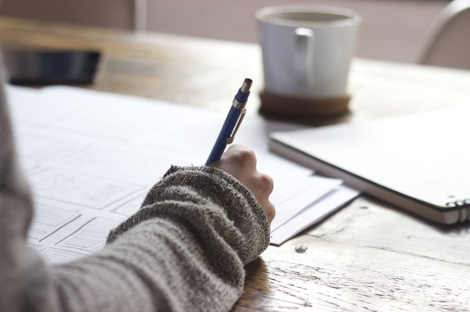 Professional copywriter brainstorming and writing ideas down on paper