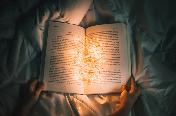 An open book with fairy lights illuminating the pages