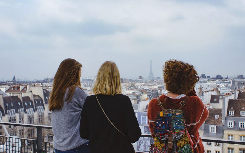 Three female tourists enjoying the view of the Paris skyline.