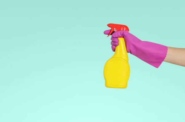 A gloved hand holds a disinfectant spray. Enhanced cleaning will be expected by New Normal Travelers choosing to stay at hotels.