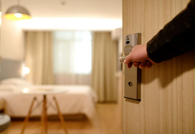 Pictured: man opens the door to his hotel room